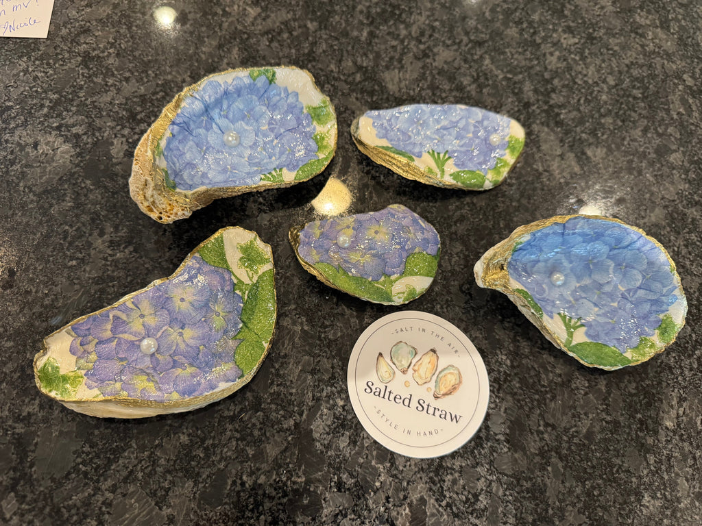 Decorative oysters with hydrangea patterns on a dark surface, featuring a 'Salted Straw' branded label.